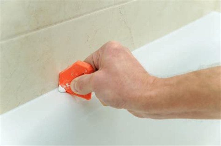 How do you remove stubborn caulk from a bathtub?
